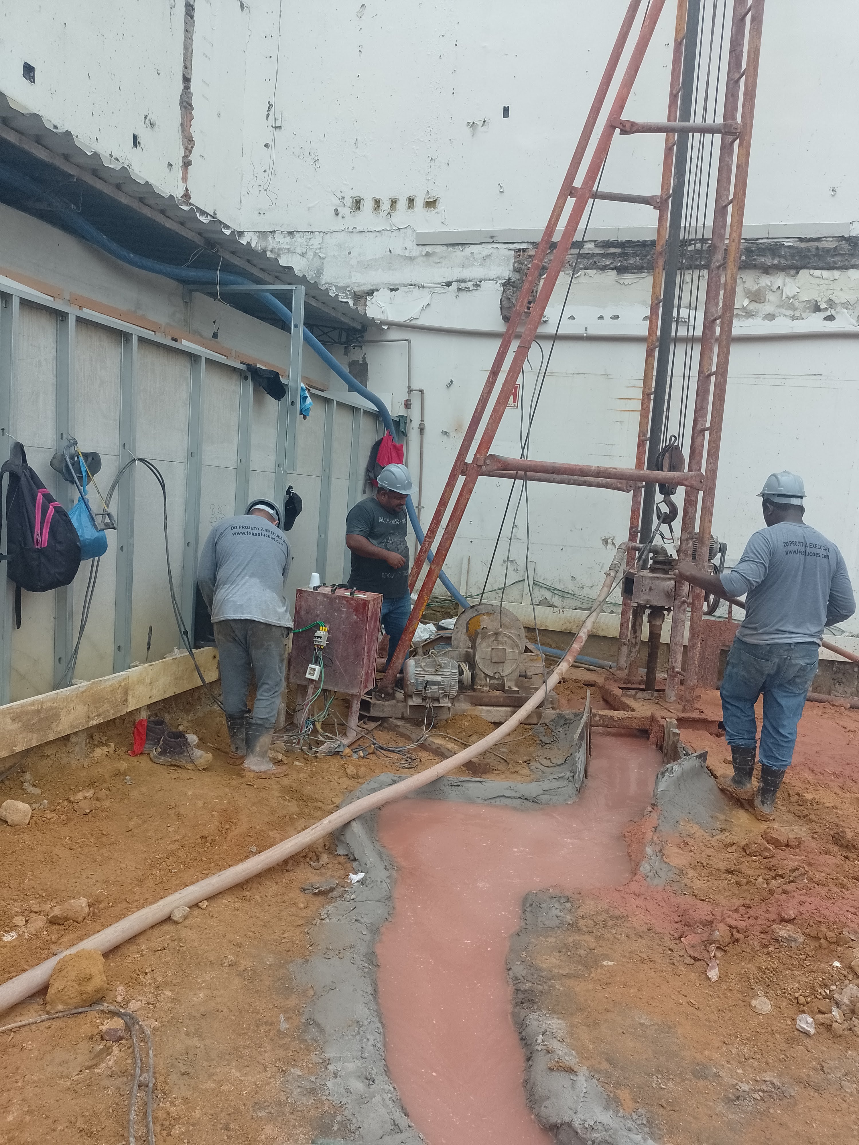 Equipe operando equipamento de perfuração em área urbana